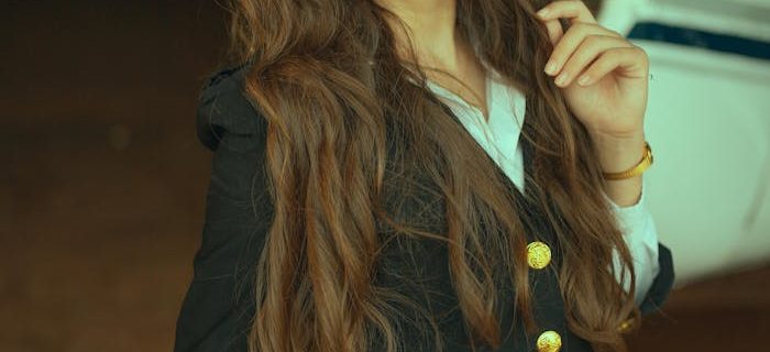 Confident young woman in pilot uniform posing inside an aircraft hangar. Fashion meets aviation.